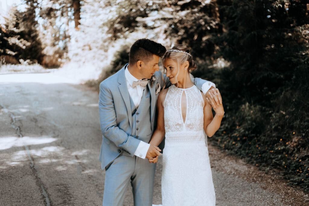Schönes Brautpaar umarmt sich beim Shooting im Nordschwarzwald. Bräutigam trägt Anzug in hellblau.