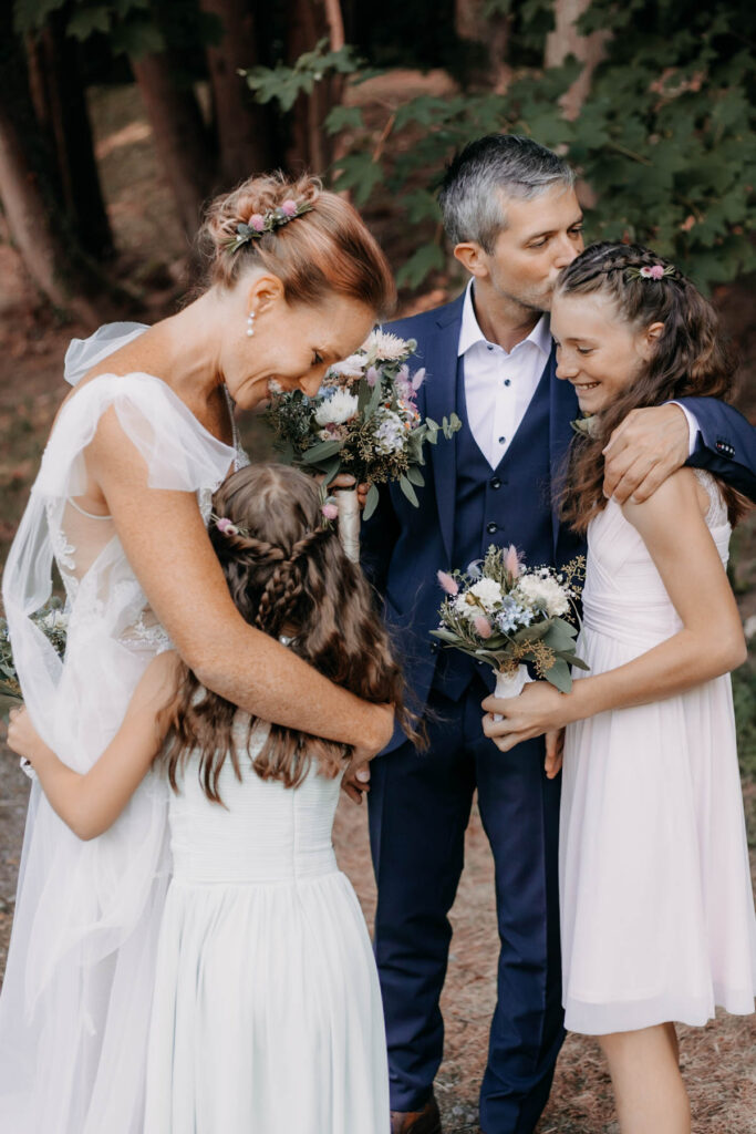 Brautpaar mit ihren Kindern beim Shooting im Grünen.